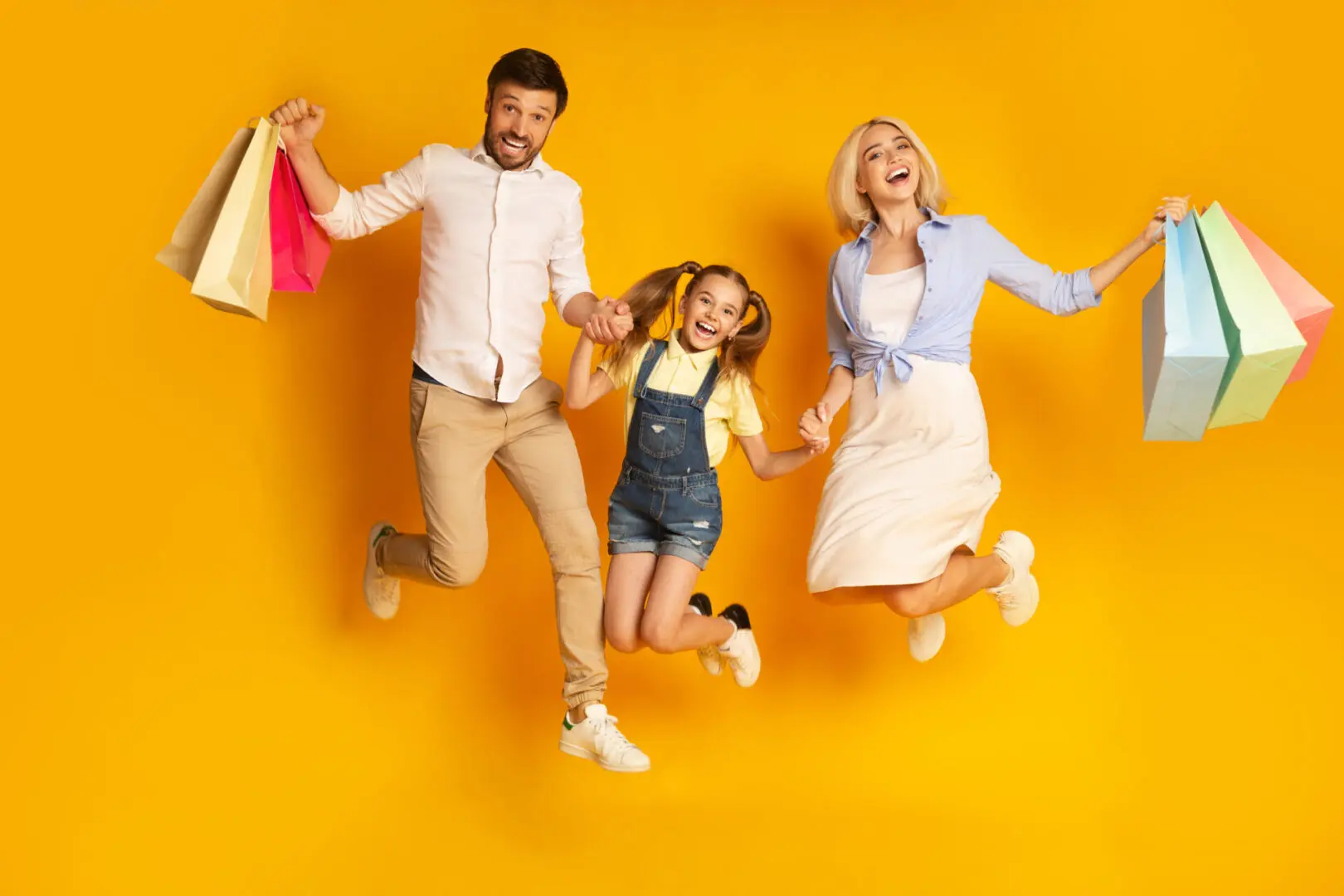 Shopping,Together.,Happy,Family,Of,Three,Jumping,Holding,Shopper,Bags